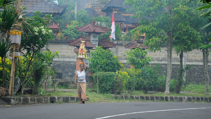 Die Herstellung der Opfergaben ist auf Bali traditionell die Aufgabe der Frauen Frau mit Opfergaben in Bangli, Bali