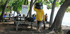 Die Mitglieder des Diving Helper Club in Tulamben bringen die Tauchausrüstung zum Wasser und zurück Diving Helper mit Tauchflasche in Tulamben, Bali
