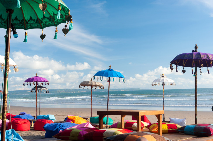 Die Gili Trawangan ist die Partyinsel unter der Gilis. Entsprechend bunt geht es in den vielen Bars und Beachclubs zu, nur so leer ist es allenfalls am frühen Morgen. Strand mit Sitzkissen auf der Gili Trawangan, Indonesien